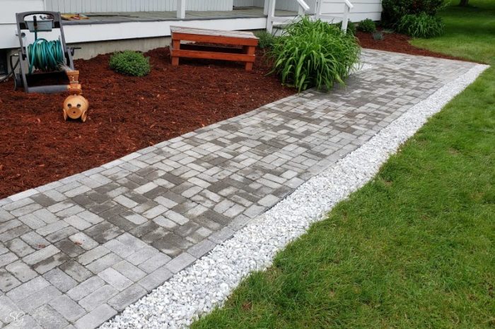 How To Install A DIY Paver Walkway, Mulch and marble chip rocks bordering our DIY paver walkway installation.