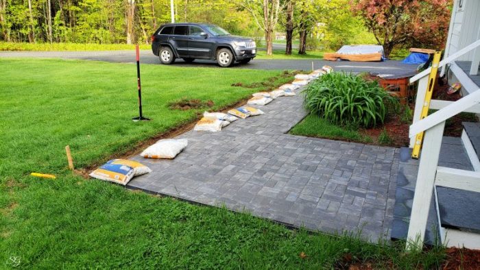 How To Install A DIY Paver Walkway, Adding marble rock border to walkway installation.