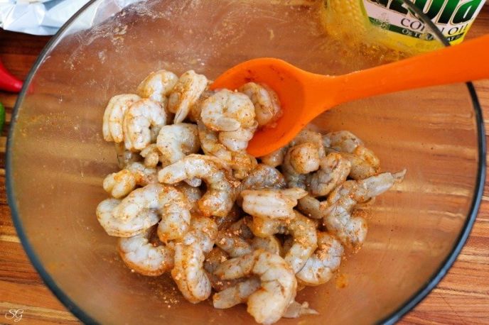 Sheet Pan Shrimp Fajitas Recipe, Seasoning shrimp for fajitas with taco seasoning and corn oil.