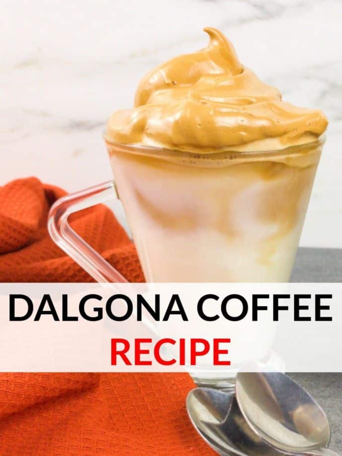 TikTok Dalgona Coffee, Dalgona coffee recipe. Whipped coffee on top of delicious creamer with ice in a clear mug next to an orange towel with spoons on the table, too.