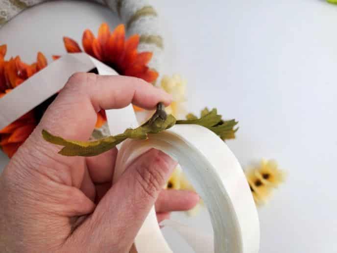 Thanksgiving Wreath, Apply glue to the back of the fake flowers to stick on the wreath