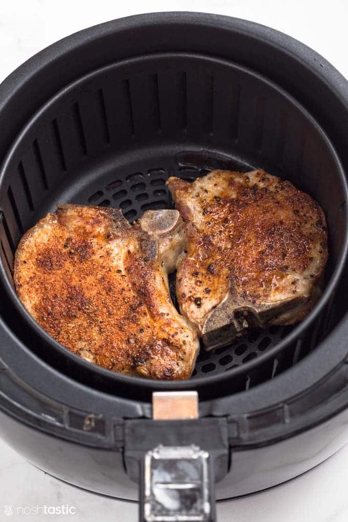 How To Use An Air Fryer Pork chops inside the air fryer basket for an easy air fryer pork chop recipe