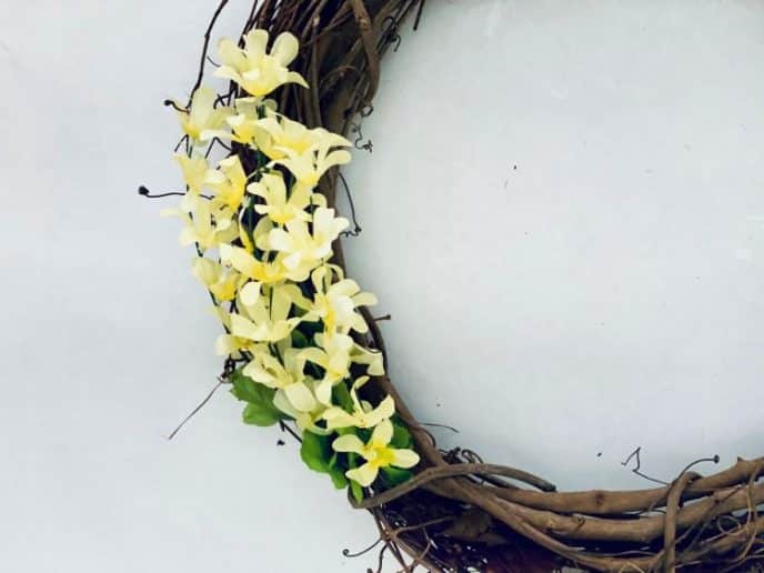 How to Make A Flower Wreath with Daffodils Attaching dripping blossoms to the grapevine wreath.