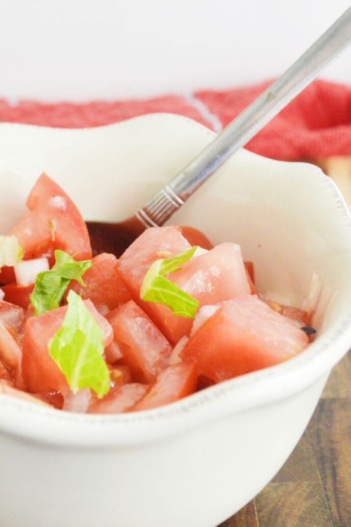 Tomato salad recipe completed in served in a white bowl