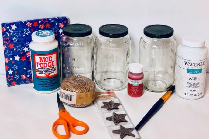 Patriotic Mason Jars Materials such as paint, fabric, jars, glue, scissors, and decorative stars to make 4th of July decorative jars.