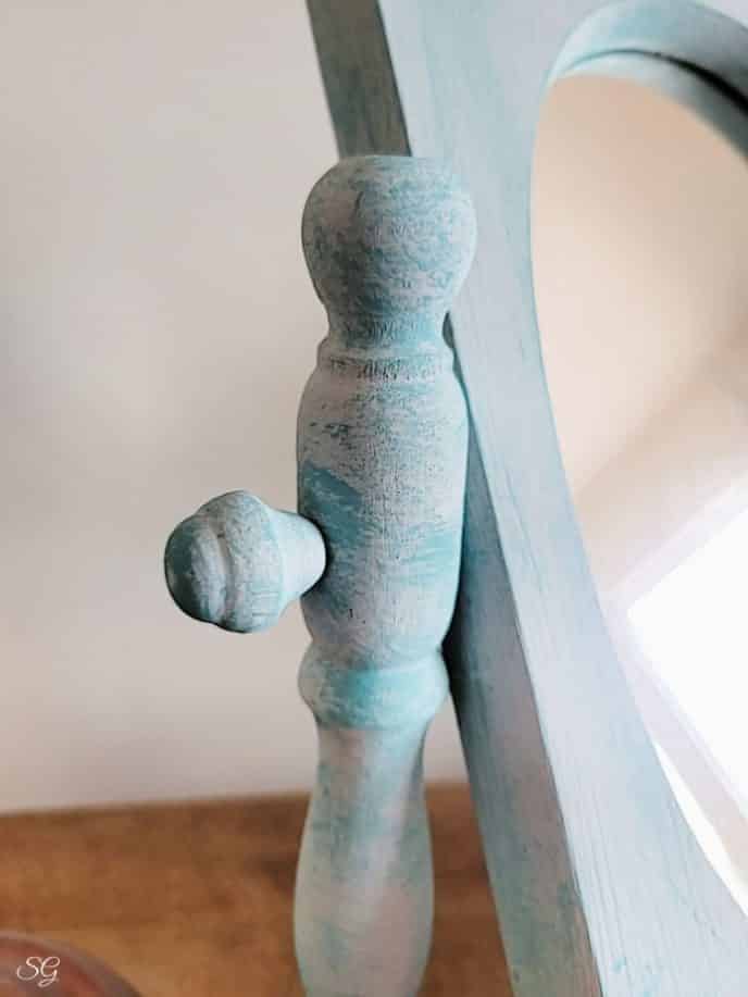 Painting A Mirror Frame Dry brushed paint on the spindle that holds the mirror onto the vanity piece.