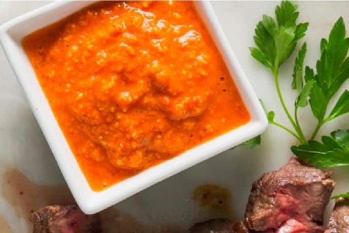 Romesco sauce with garnish on the side of the dish