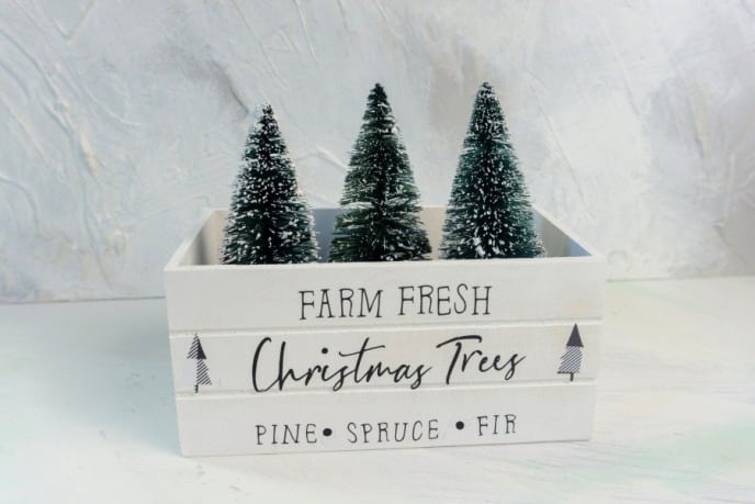 Farm Fresh Christmas Tree Cricut Design on a White Crate with Christmas Trees Inside of the Crate