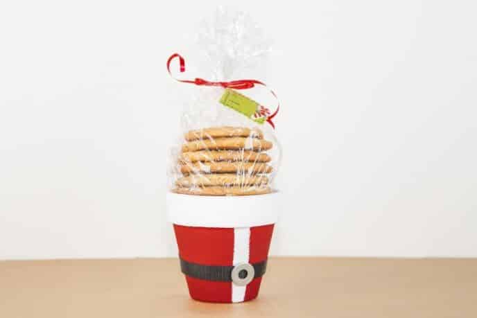 Santa cookie bucket DIY Christmas gift for neighbors; clay pot painted like Santa's jacket and filled with cookies.