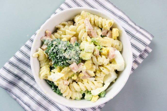 Pasta salad recipe with ham, broccoli, avocado, and dressing.